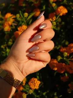 Mano femenina con manicura en gel sosteniendo una flor