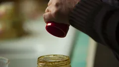 Persona sosteniendo vaso plástico rojo con bebida