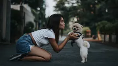 Mujer acariciando perro Pomerania con fondo natural