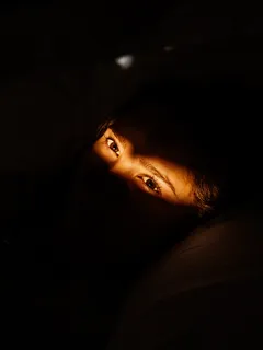 Mujer tumbada sobre tejido negro en foto creativa para hogar