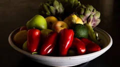 Pimientos rojos y verdes en plato cerámico blanco sobre fondo blanco
