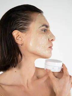 Mujer con mascarilla facial cuidando su piel