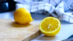Dos naranjas frescas sobre una tabla de cortar de madera
